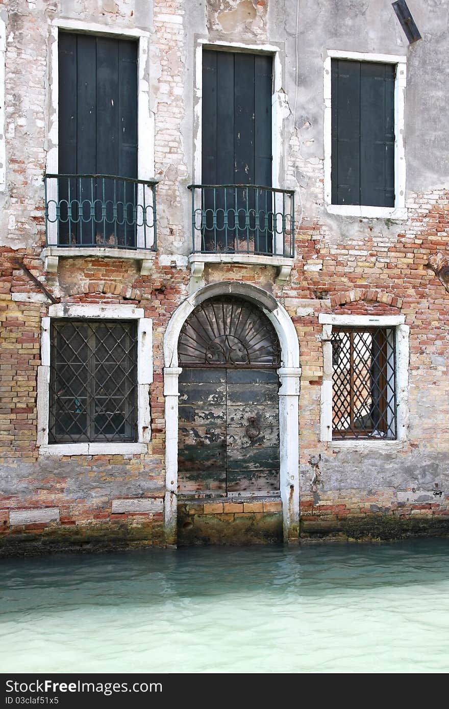 Fastened with nails doors in a house, going out on a channel, Venice, Italy. Fastened with nails doors in a house, going out on a channel, Venice, Italy