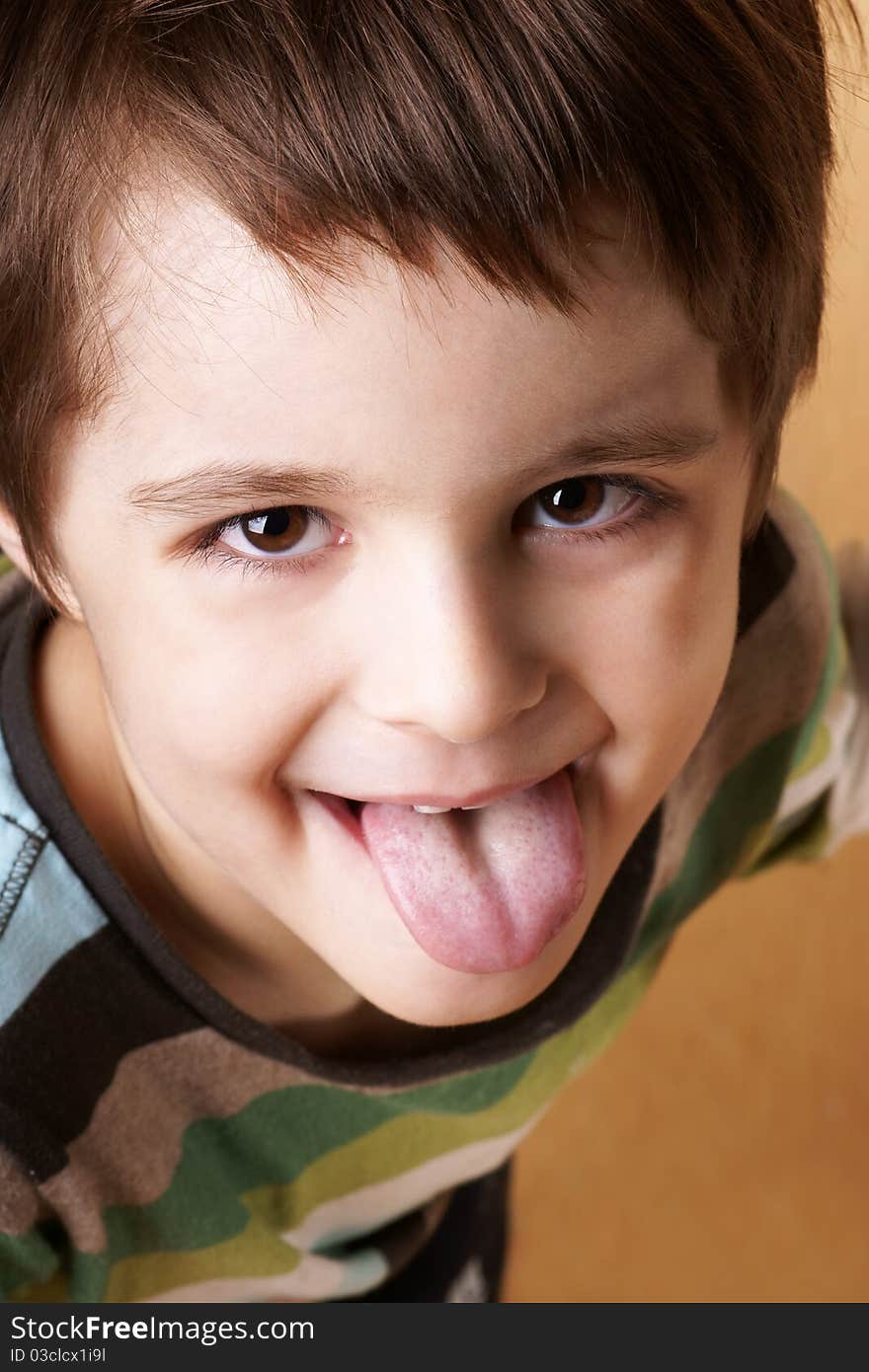 Portrait of joyful playful cute little boy showing tongue, studio shot. Portrait of joyful playful cute little boy showing tongue, studio shot