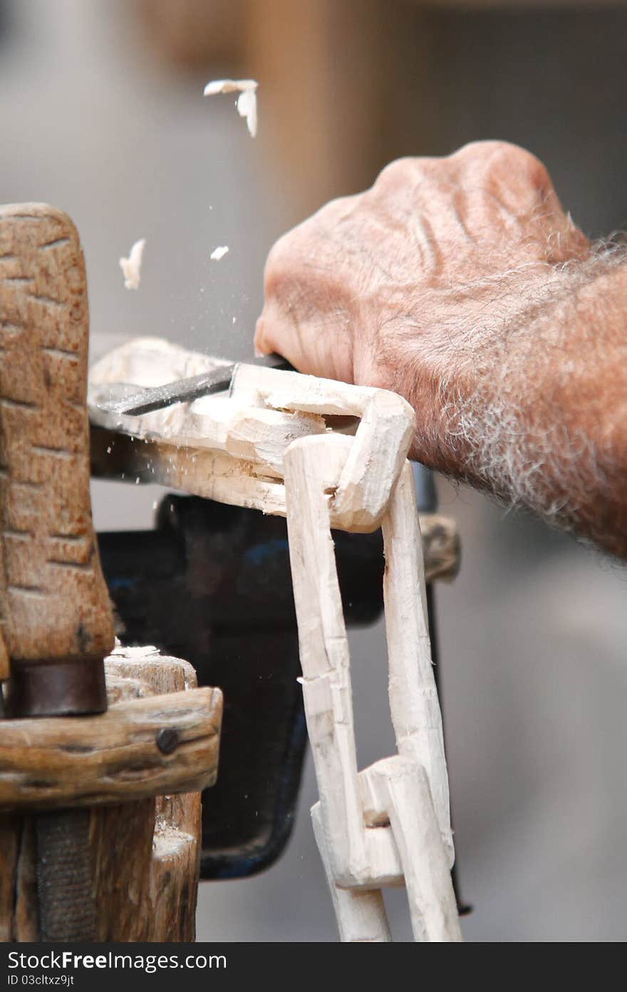 Carpenter carving a wood chain in a traditional fair. Carpenter carving a wood chain in a traditional fair