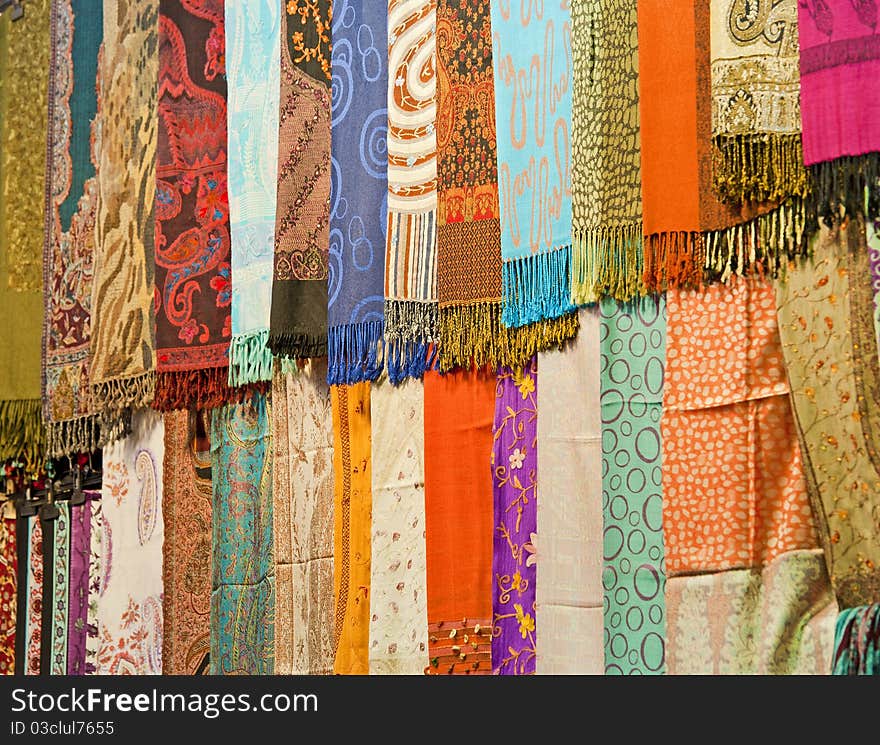 Rows of fabrics hanging at a market stall. Rows of fabrics hanging at a market stall