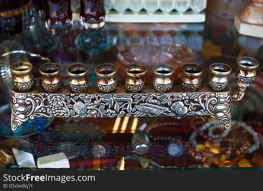 Antique decorative candlestick for Hanukkah holyday.Simple form, decorated metal, hebrew letters, colorful background.Jerusalem fleamarket. Antique decorative candlestick for Hanukkah holyday.Simple form, decorated metal, hebrew letters, colorful background.Jerusalem fleamarket.