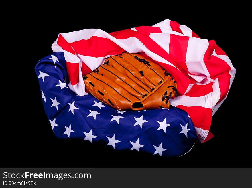 A baseball glove resting on an American flag. American supports baseball. A baseball glove resting on an American flag. American supports baseball.