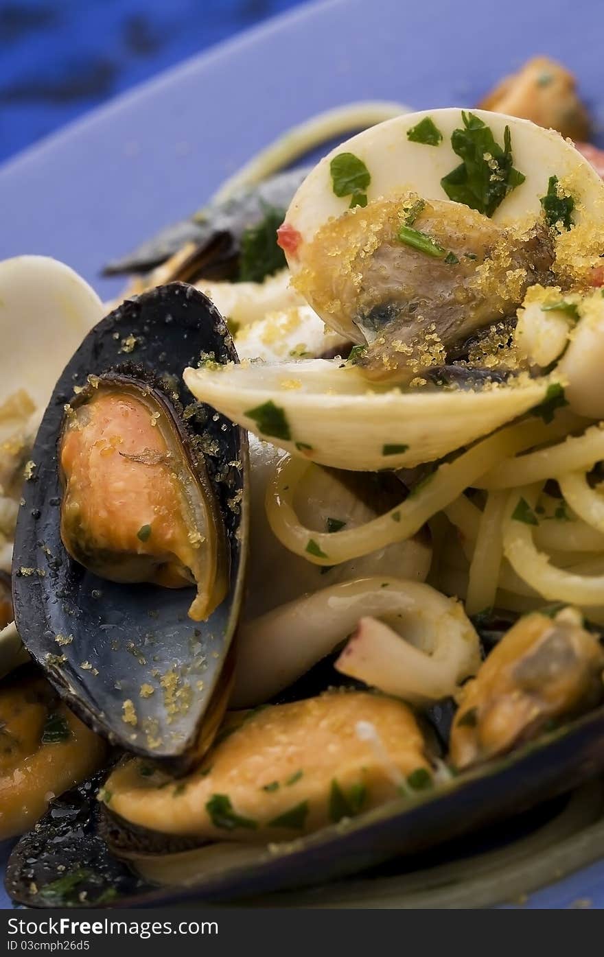 Spaghetti with seafood on blue dish