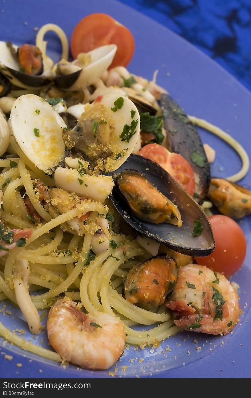 Spaghetti with seafood on blue dish