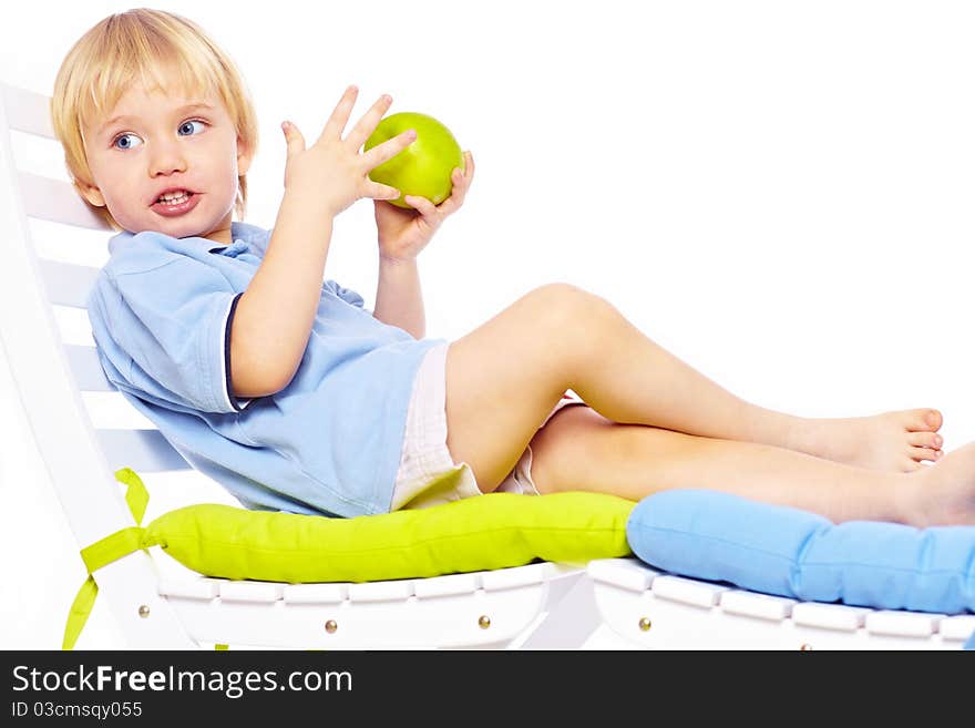 Little boy relaxing on chair with apple isolated over white. Little boy relaxing on chair with apple isolated over white