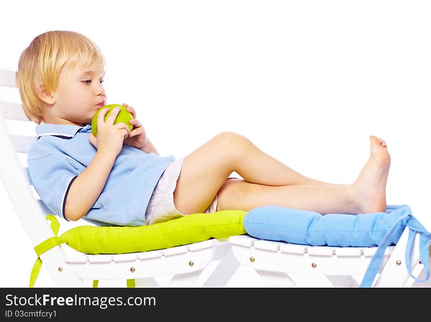 Little boy relaxing on chair with apple isolated over white back. Little boy relaxing on chair with apple isolated over white back