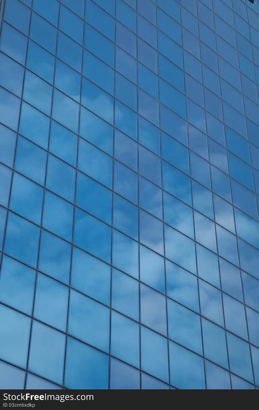 Architectural glass feature reflects cloudscape and blue sky. Architectural glass feature reflects cloudscape and blue sky.