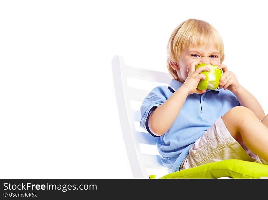 Little boy on chair with apple isolated over white background. Little boy on chair with apple isolated over white background