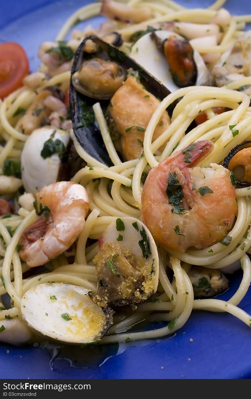 Spaghetti with seafood on blue dish