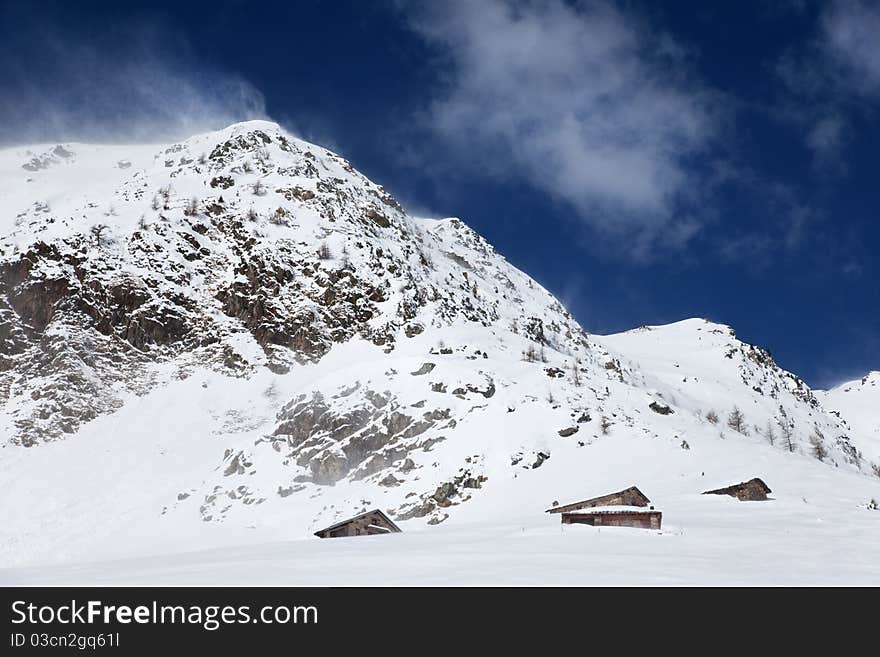 Cabins in a mountain valley in the North of Italy during a wind storm. Brixia province, Lombardy region, Italy. Cabins in a mountain valley in the North of Italy during a wind storm. Brixia province, Lombardy region, Italy