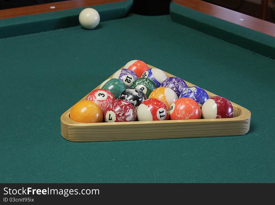 Arranged the balls in a triangular shape to start a game of pool. Arranged the balls in a triangular shape to start a game of pool