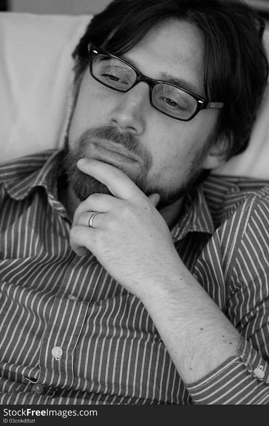 This is a black and white photograph of a married man wearing glasses and on a thinking position. Photo taken with Canon EF 100mm f/2.8 L Macro IS USM. This is a black and white photograph of a married man wearing glasses and on a thinking position. Photo taken with Canon EF 100mm f/2.8 L Macro IS USM