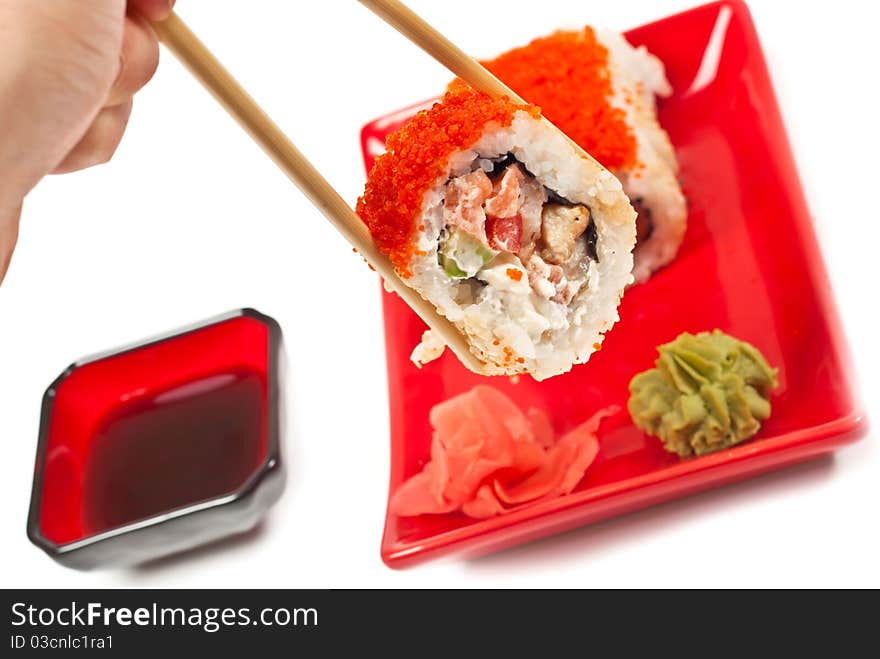 Men's hand holding sushi served on a plate. White background