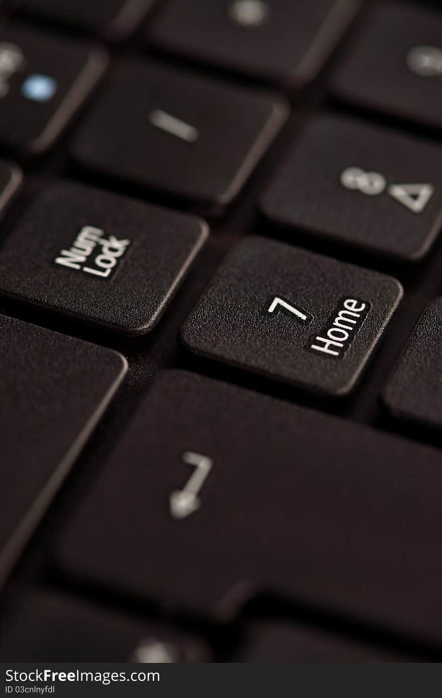 Black notebook keyboard with focus on home key, closeup. Black notebook keyboard with focus on home key, closeup