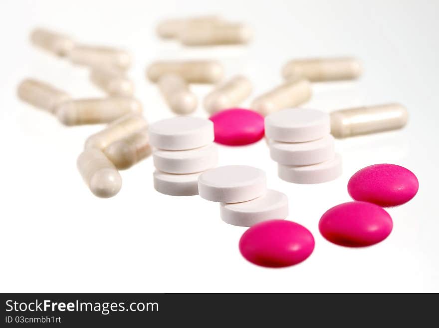 Pink and white pills on a white background. Pink and white pills on a white background