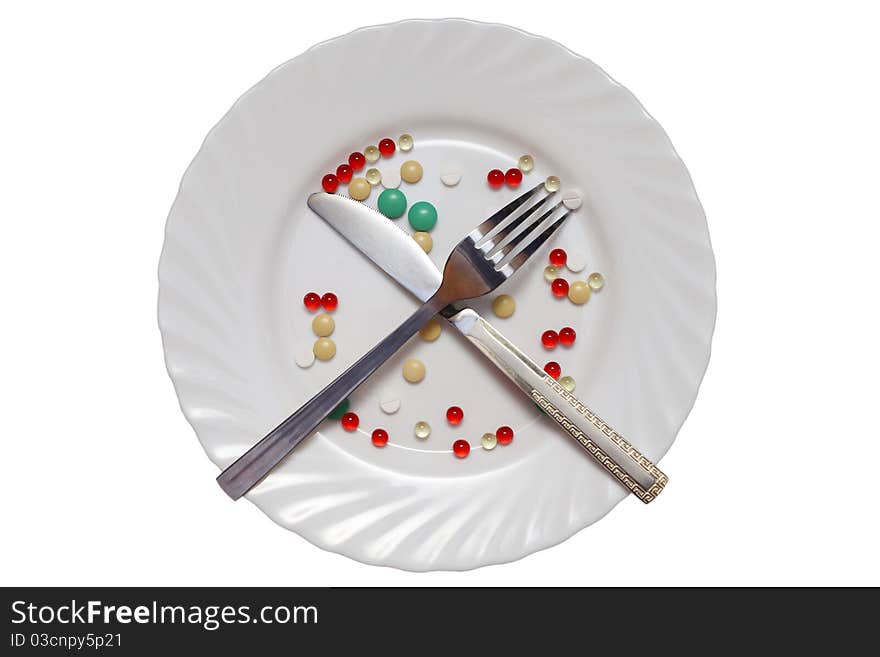 Vitamin photo on a white plate, the fork and a knife. Vitamin photo on a white plate, the fork and a knife