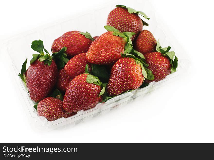 Fresh strawberries in a plastic container on a white background, top view