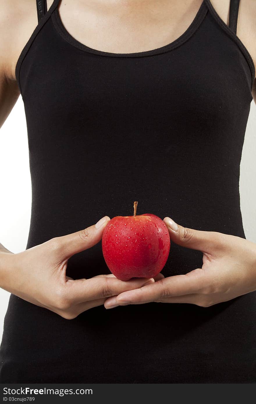 A woman with black tank top holding an apple. A woman with black tank top holding an apple.