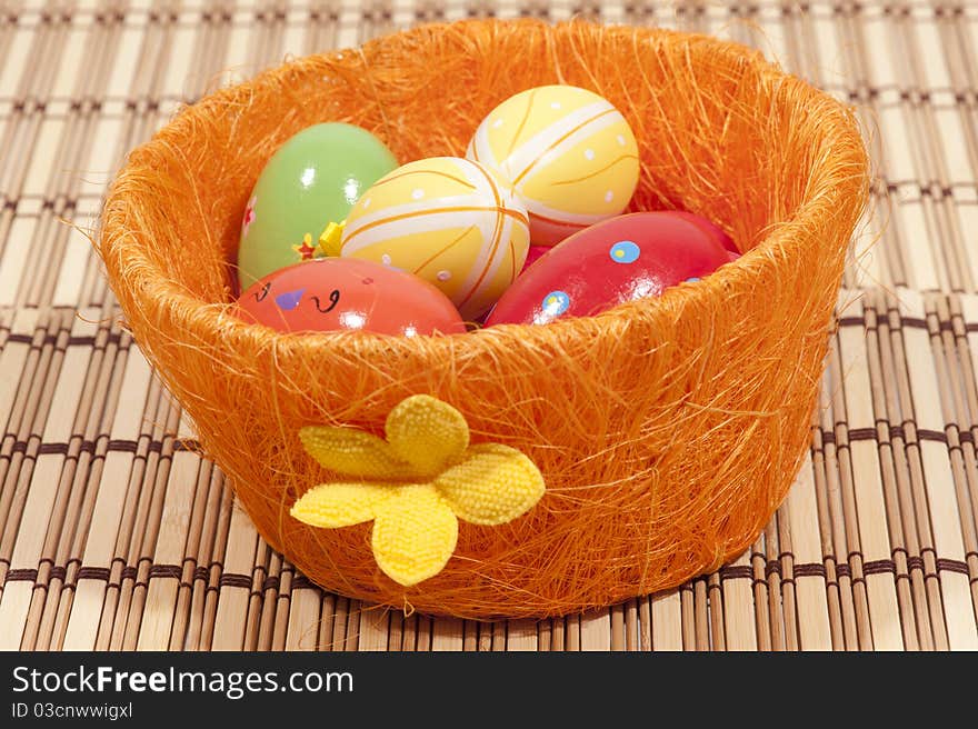 Colorful painted easter eggs in orange basket