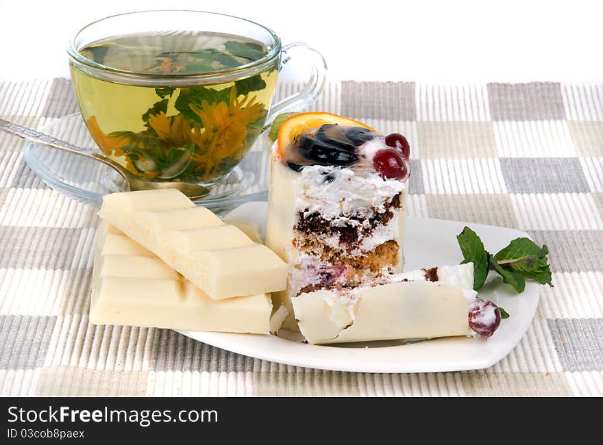 Herbal tea and cake on textile mat