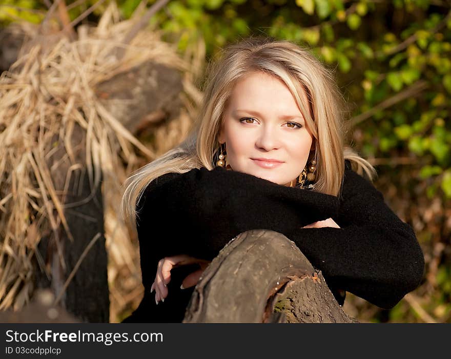 Autumn portrait of a blonde girl who looking at the frame