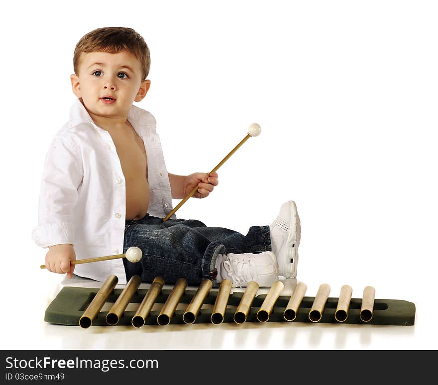 An adorable baby boy playing golden xylophone-style pipes. Isolated on white. An adorable baby boy playing golden xylophone-style pipes. Isolated on white.