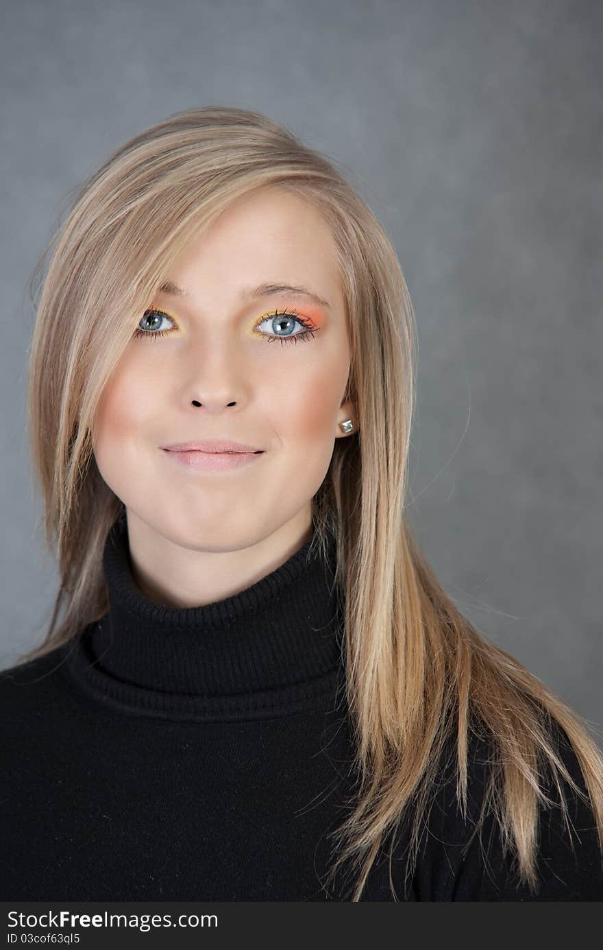 Portrait of smiling blond woman on gray background