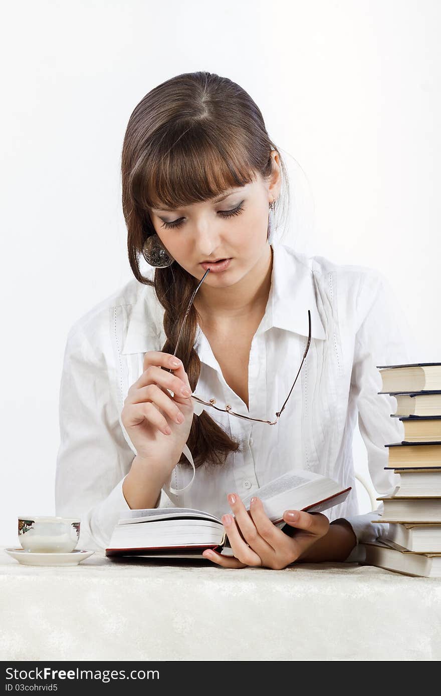 Beautiful Girl Reading A Book On The Table