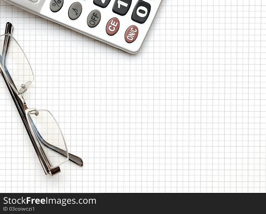 Eyeglass, and calculator on the working paper