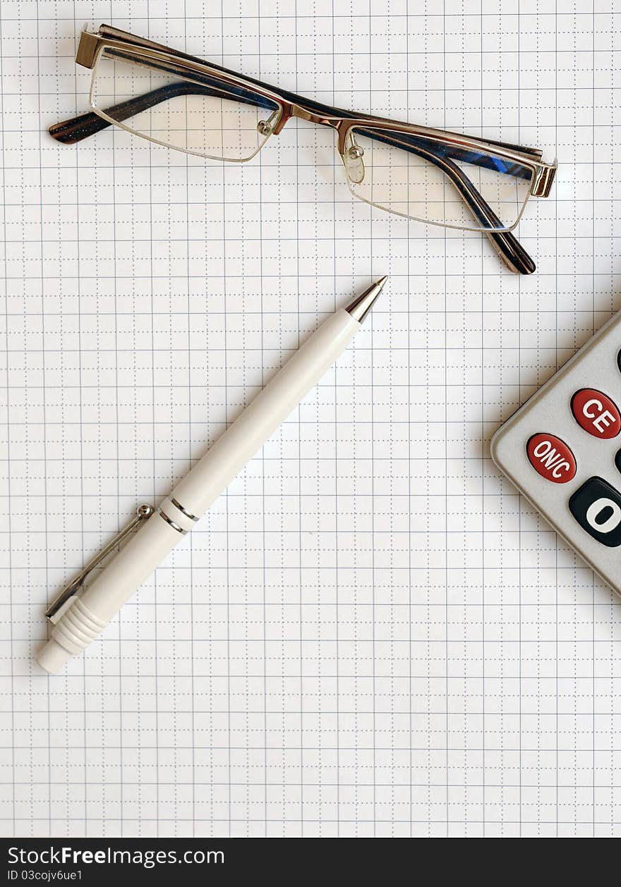 Pen, eyeglass, and calculator on the working paper