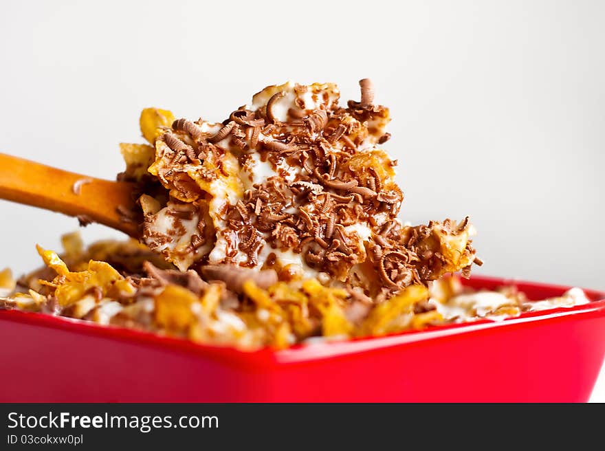 Fast and healthy breakfast. Corn flakes with milk and grated chocolate. Wooden spoon is for natural taste of this sweet food. Fast and healthy breakfast. Corn flakes with milk and grated chocolate. Wooden spoon is for natural taste of this sweet food.