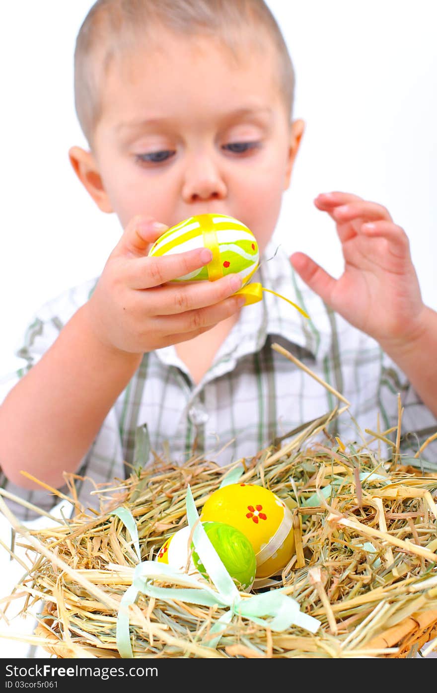 Little boy playing with easter eggs in basket. Focus on the eggs. Little boy playing with easter eggs in basket. Focus on the eggs.