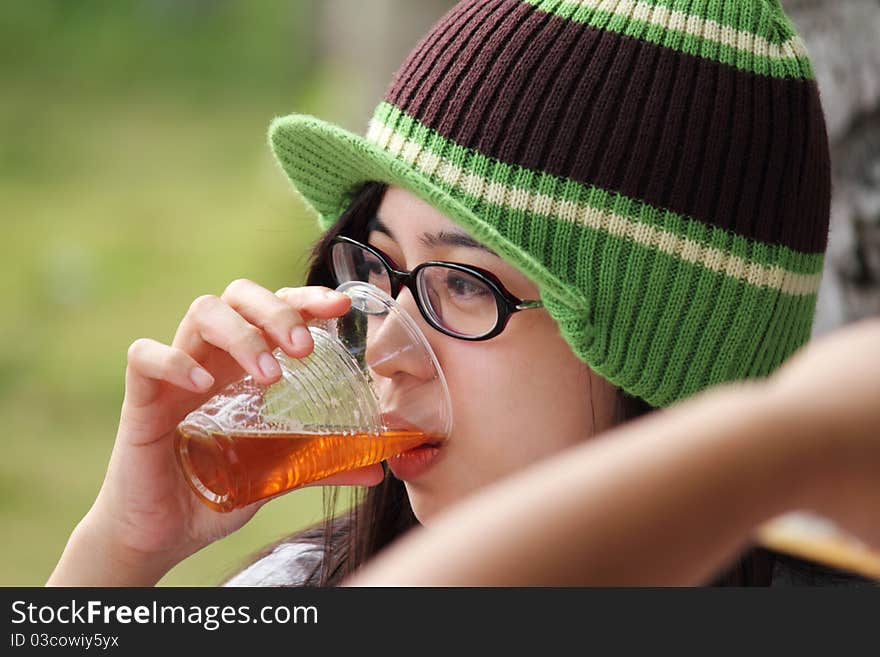 Young lady drinking beer on a plastic cup. Young lady drinking beer on a plastic cup