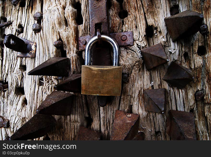 Old door with spikes and a closed padlock. Extreme Security