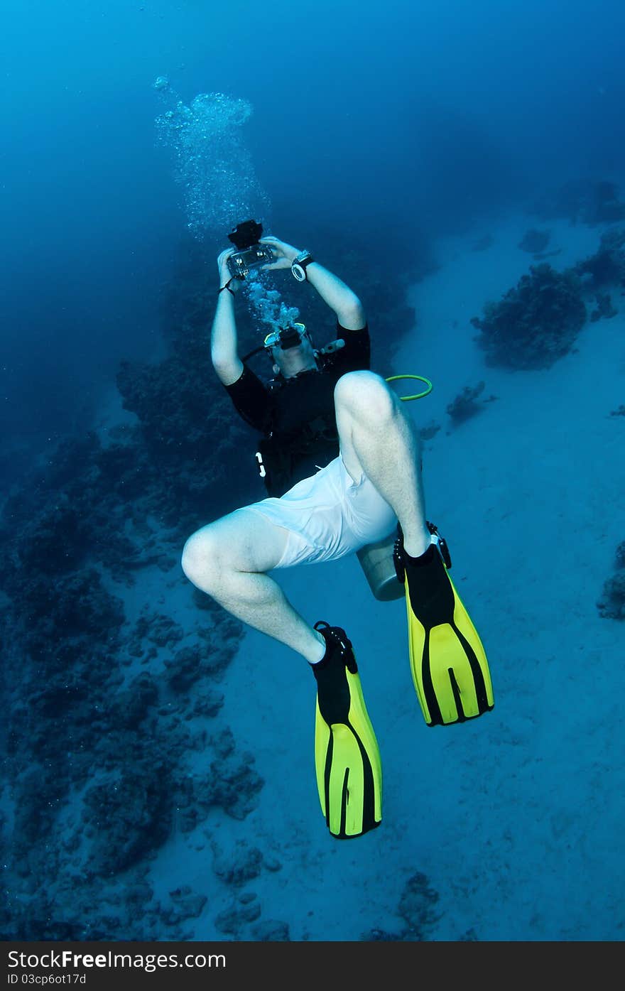 Scuba diver looks up and takes photograph