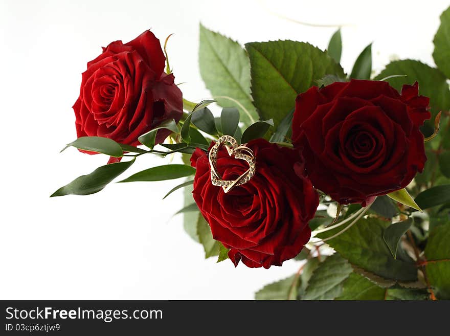 Bouquet of three red roses and gold heart on white background. Bouquet of three red roses and gold heart on white background.