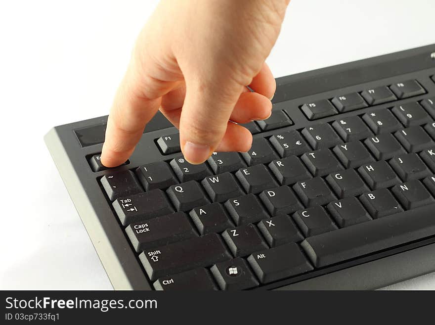 Hand on the black keyboard.