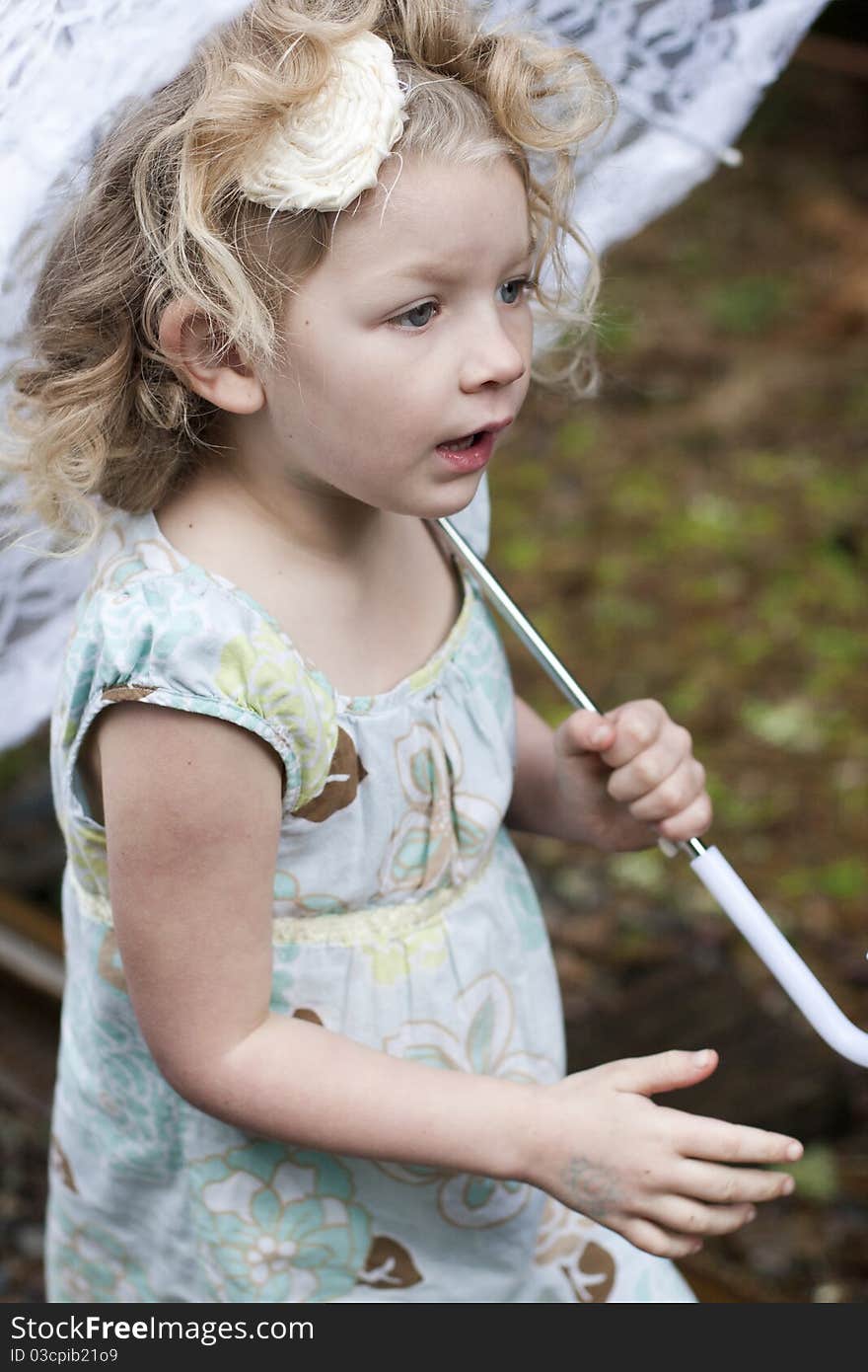 Beautiful young girl holding an umbrella while looking off to the side. Beautiful young girl holding an umbrella while looking off to the side.