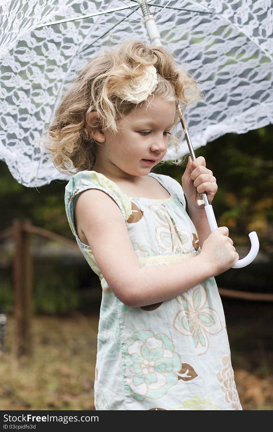 Beautiful young girl holding an umbrella while looking off to the side. Beautiful young girl holding an umbrella while looking off to the side.