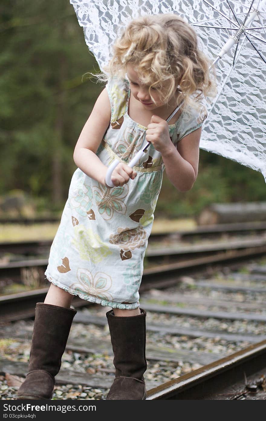 Beautiful young girl holding an umbrella while looking off to the side. Beautiful young girl holding an umbrella while looking off to the side.