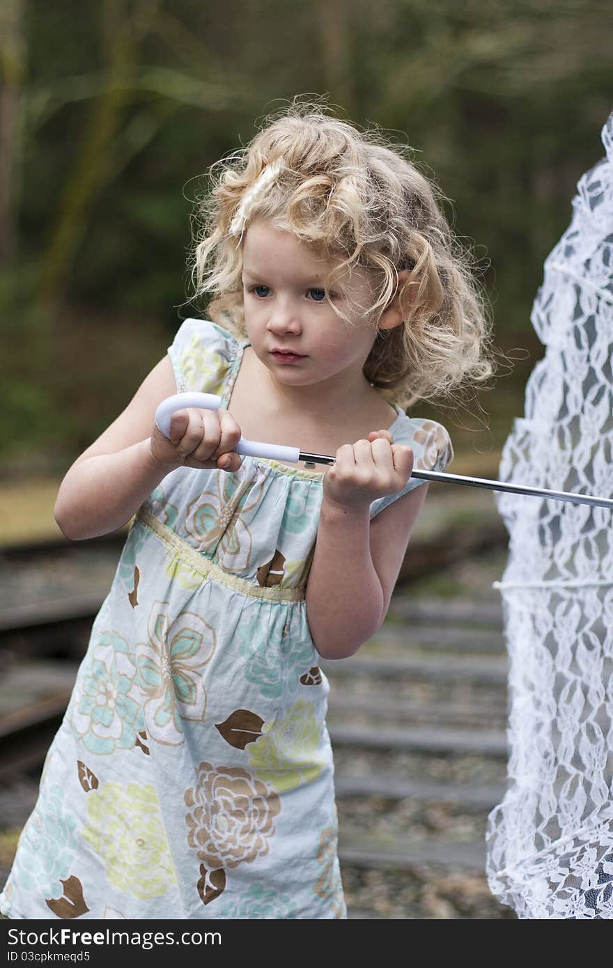 Beautiful young girl holding an umbrella while looking off to the side. Beautiful young girl holding an umbrella while looking off to the side.