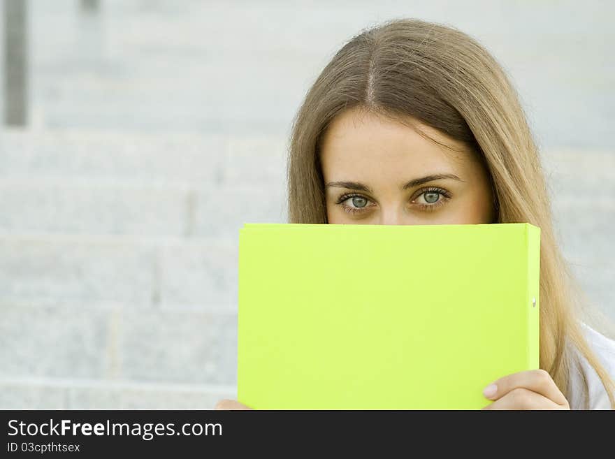 Attractive young businesswoman smiling with a green folder. Attractive young businesswoman smiling with a green folder.