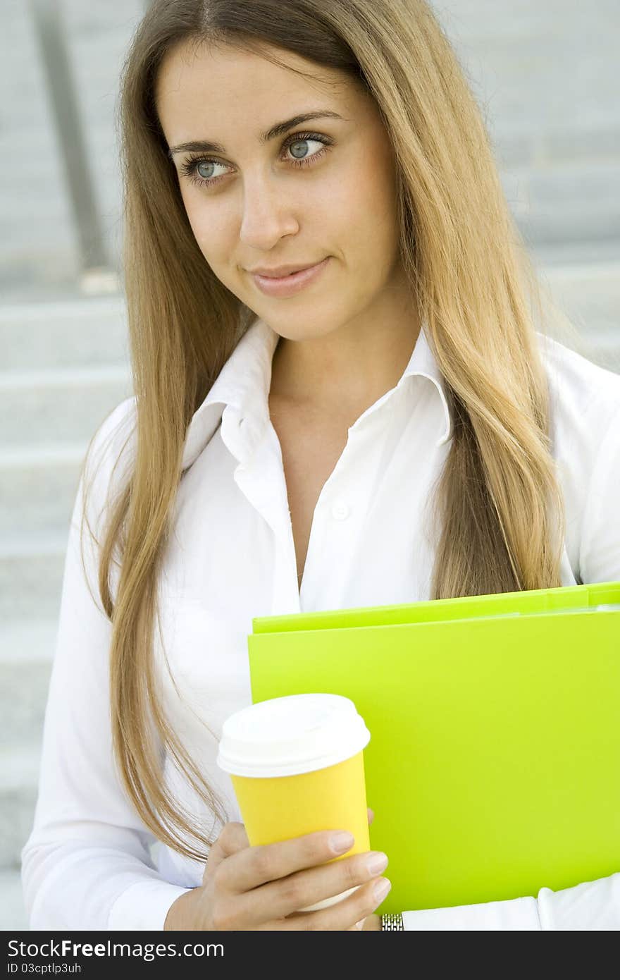 Business woman with a green folder and paper cup of coffee. Business woman with a green folder and paper cup of coffee