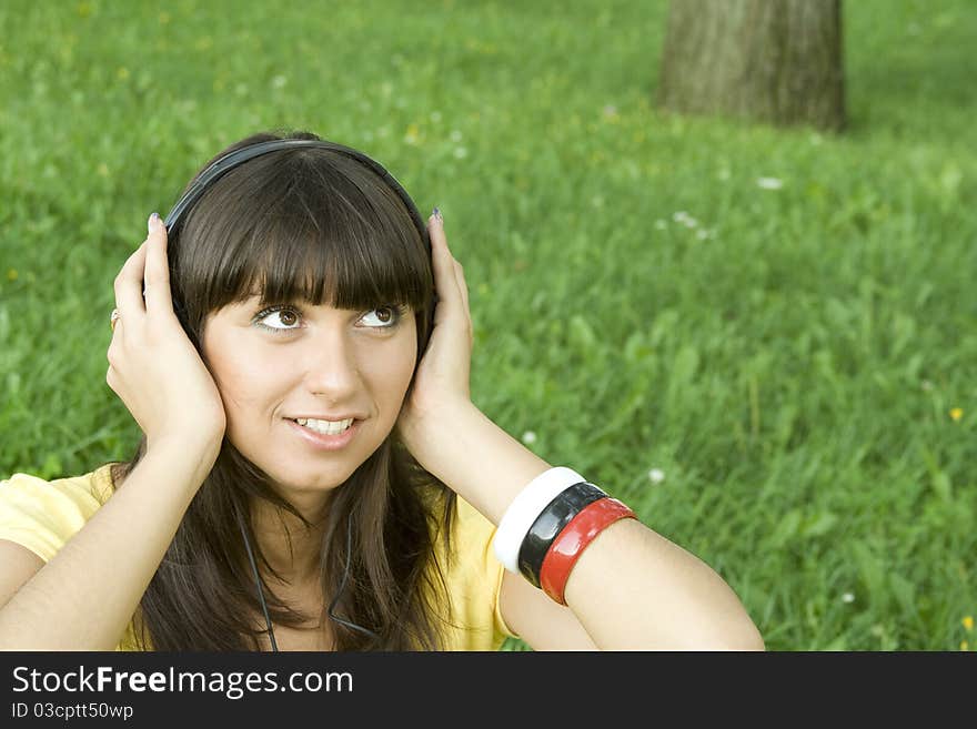 Smiling young woman listening to music at park