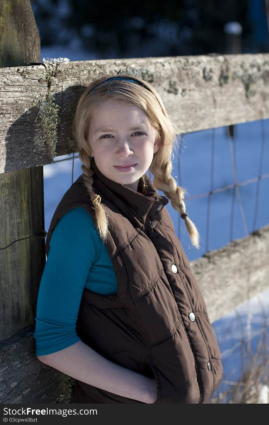 Young girl posing for the camera in a field of snow. Young girl posing for the camera in a field of snow