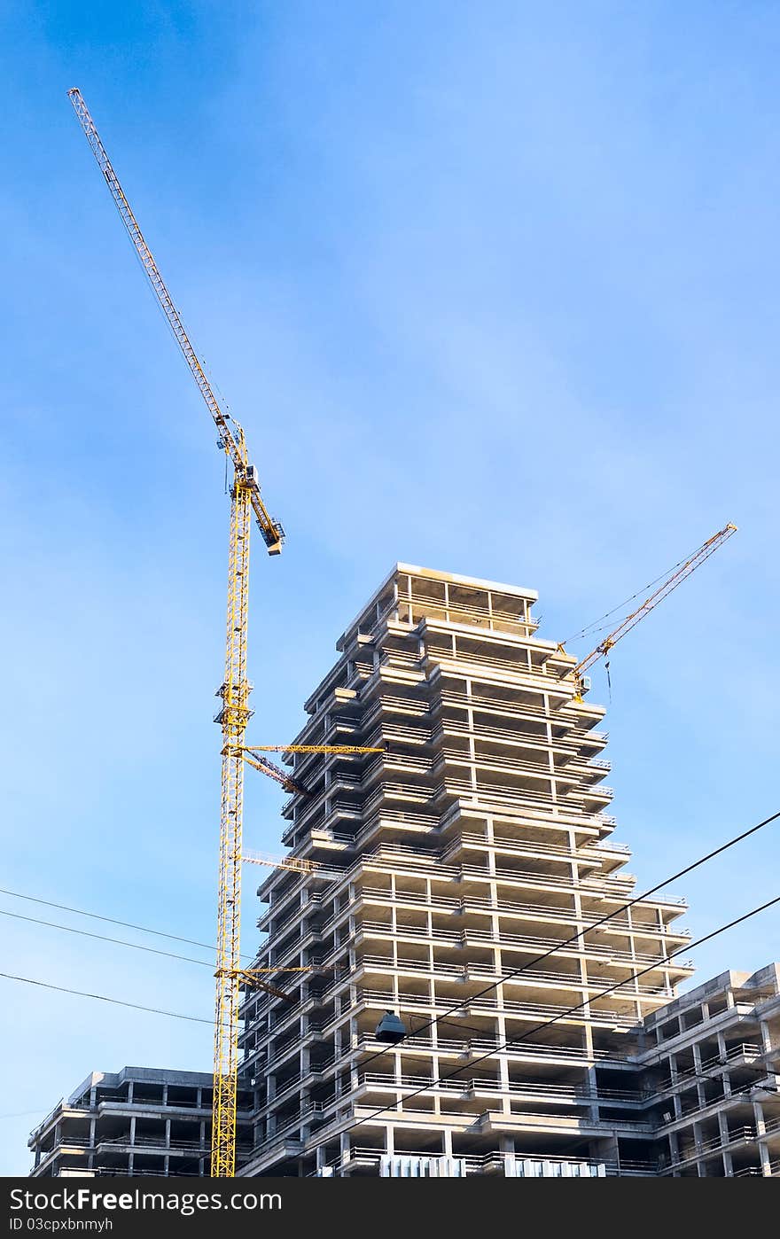 Bright yellow lift cranes on the site of high-rise building. Bright yellow lift cranes on the site of high-rise building