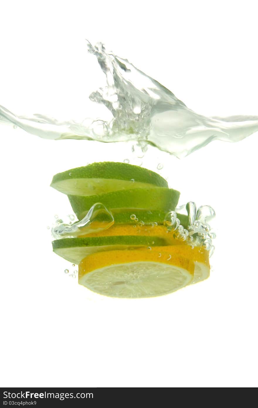 Lemon and lime thrown into the water with splash, on white background.