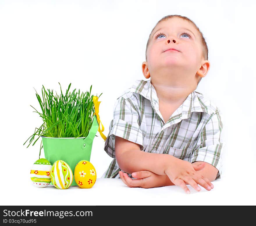 Easter egg hunt. Cute little boy with Easter eggs and basket the green spring grass Isolated on white background