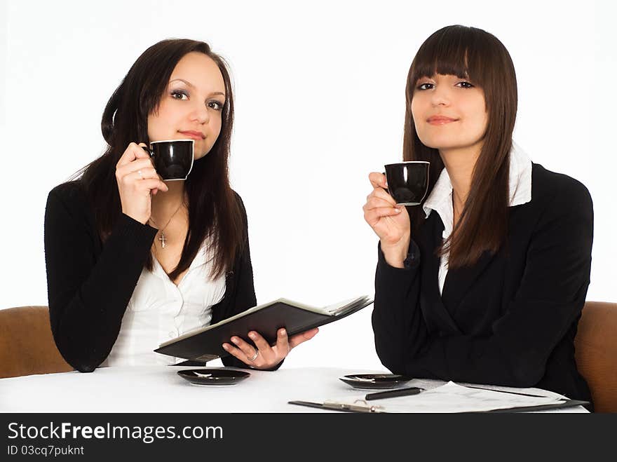 Two beautiful business women sitting at the table