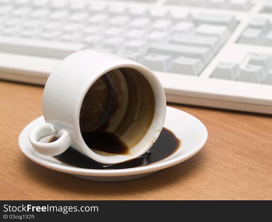 Coffee mug with inverted on a wooden table against the background keyboard